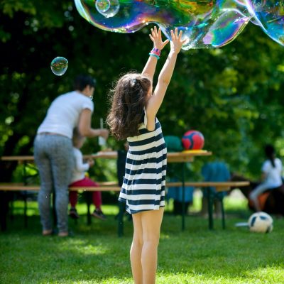 Gyerekek óriás buborékokat fújnak a parkban